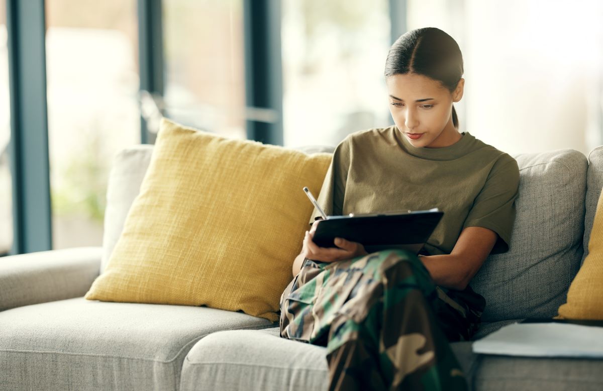 A woman, sitting on her couch at home, fills out a patient experience survey after her hospital visit.