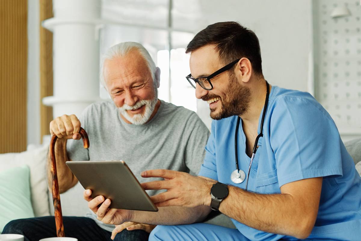 A healthcare professional shows his client his caregiver cover letter.