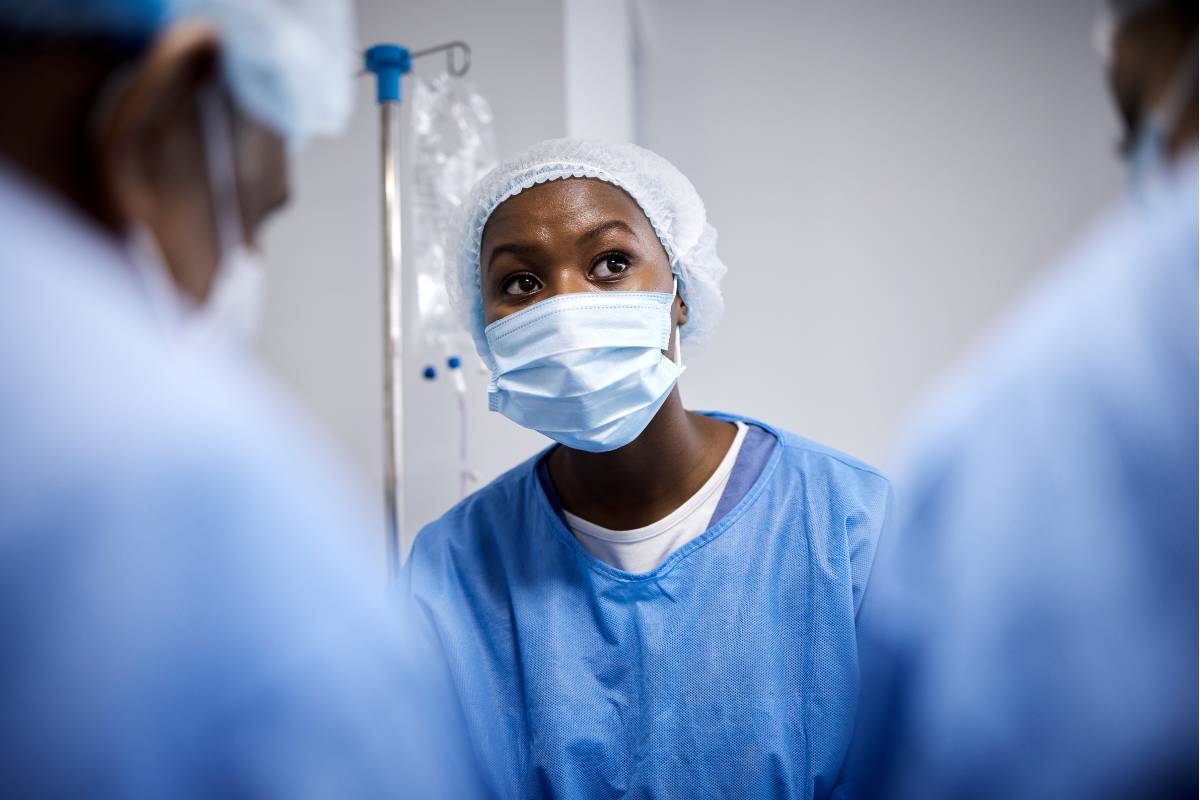 A cath lab nurse assists with a procedure.