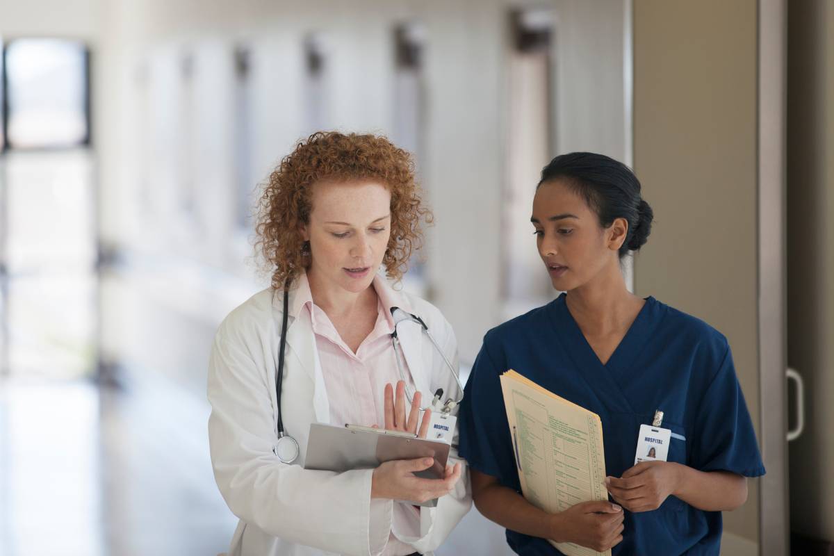 Two healthcare professionals discuss HIPAA nursing regulations.