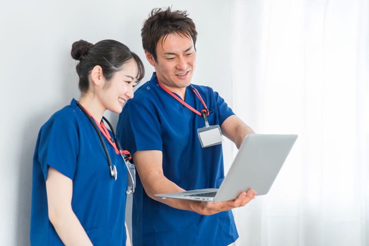 Two nurses looking together at the EHR system on a laptop computer.