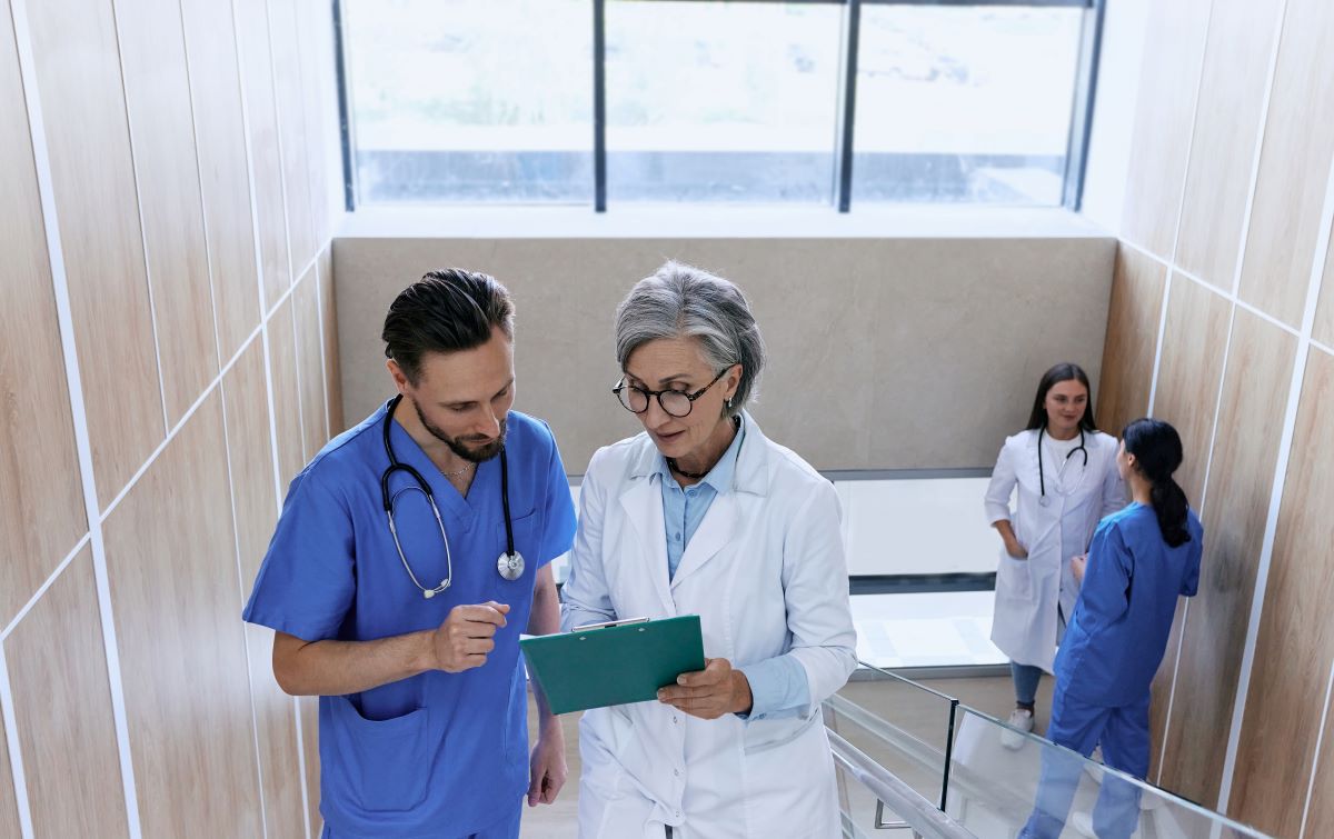 A nurse consults with his supervising physician to discuss the medical necessity of a procedure.