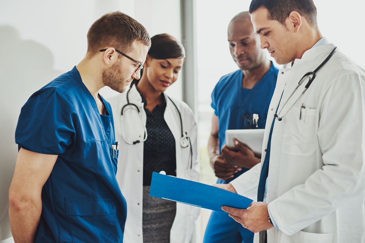 Two nurses meet with their supervising physicians.