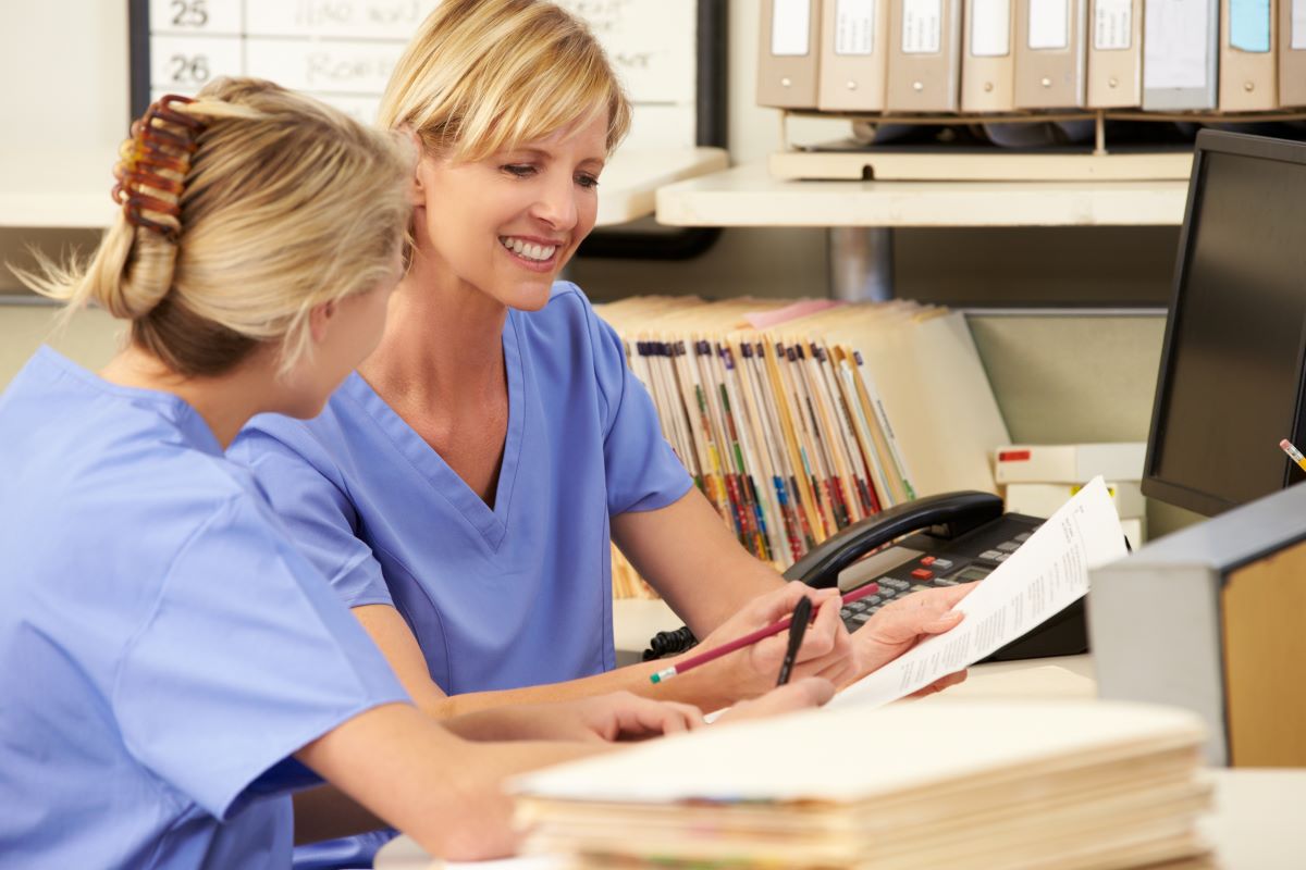 A nurse manager goes over the code of conduct with a new nurse.