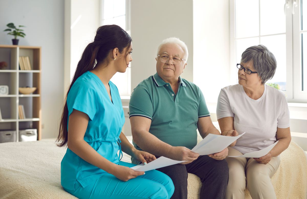 A nurse goes over various healthcare payment models with a patient and his wife.