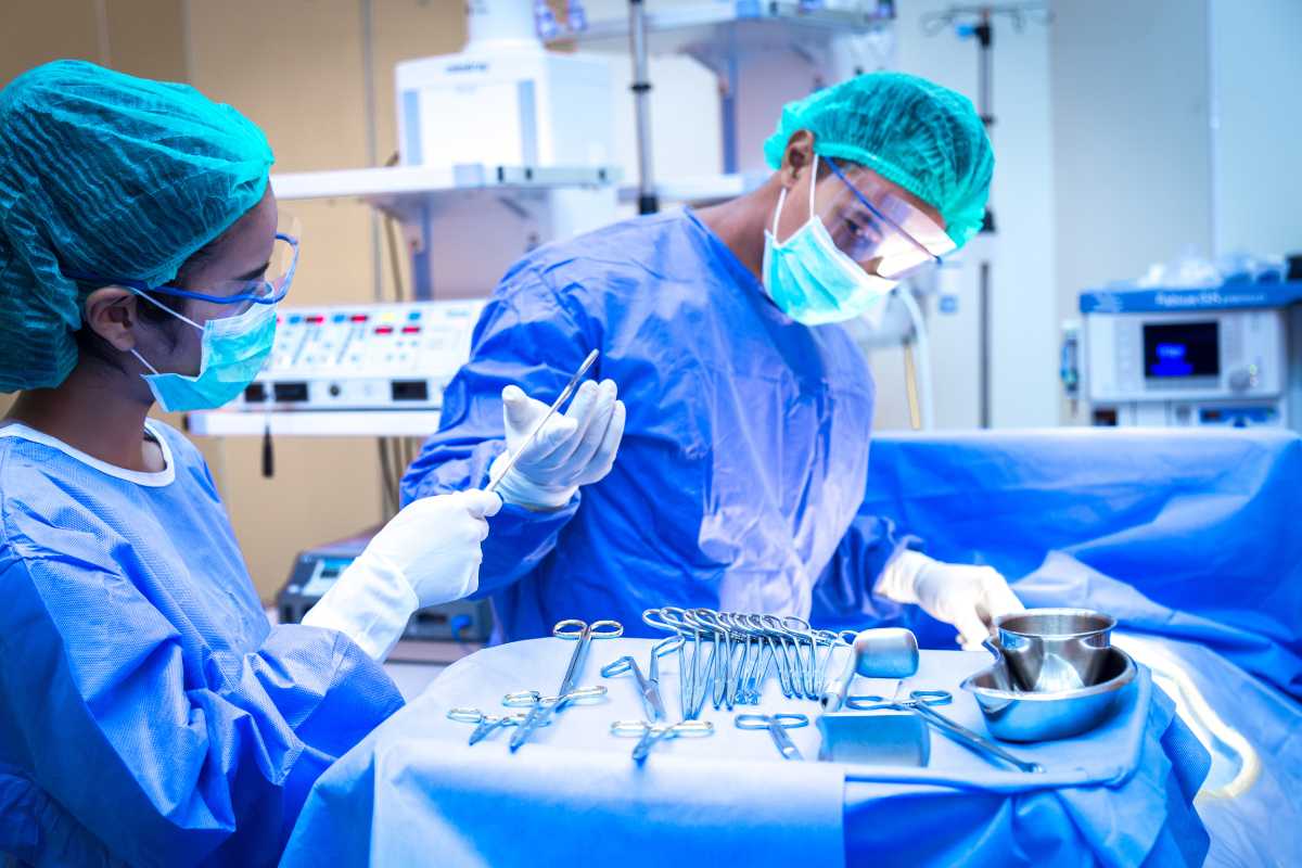 Surgical nurse handing tools to a surgeon in the OR.