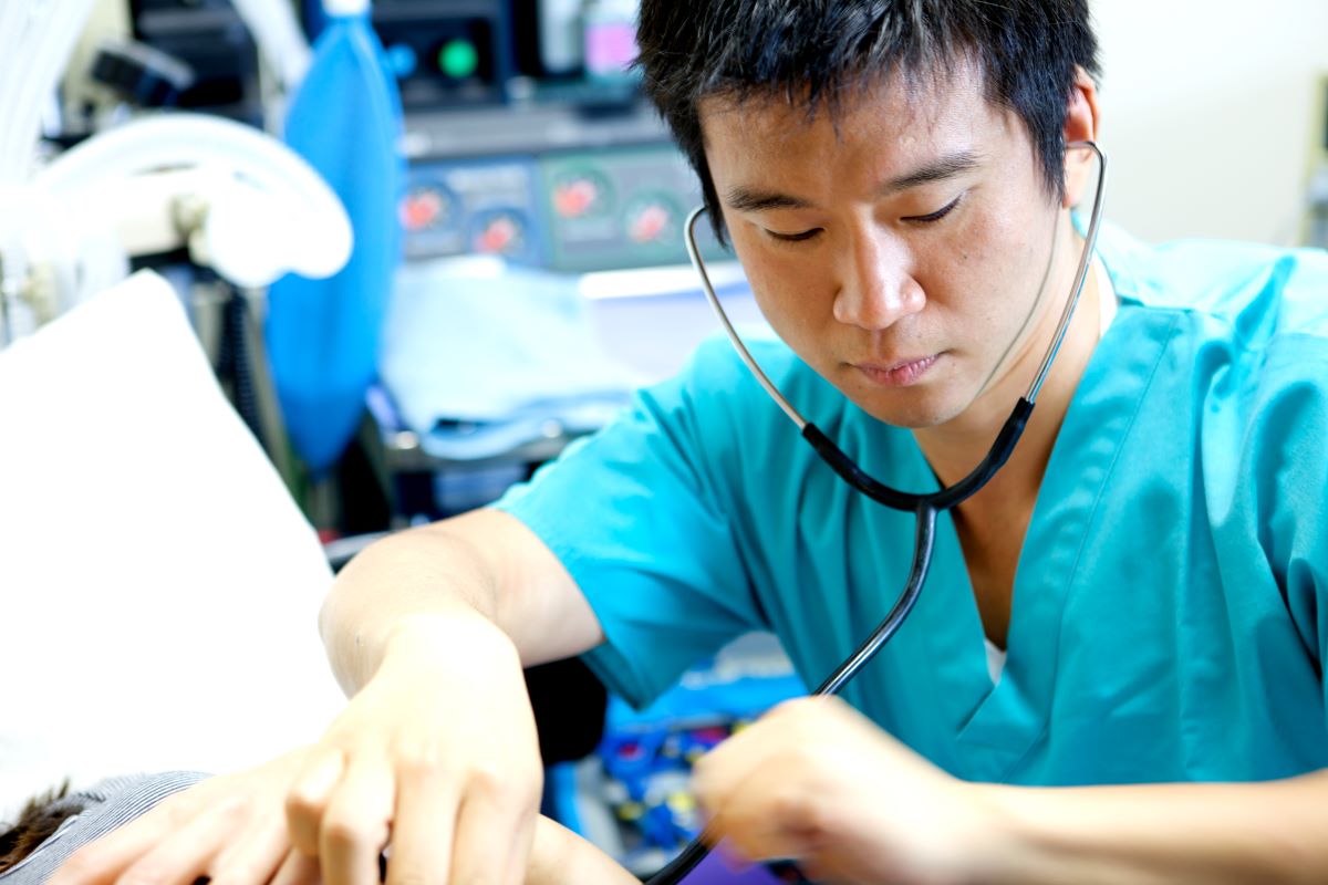 A nurse checks the heart rate of a patient.