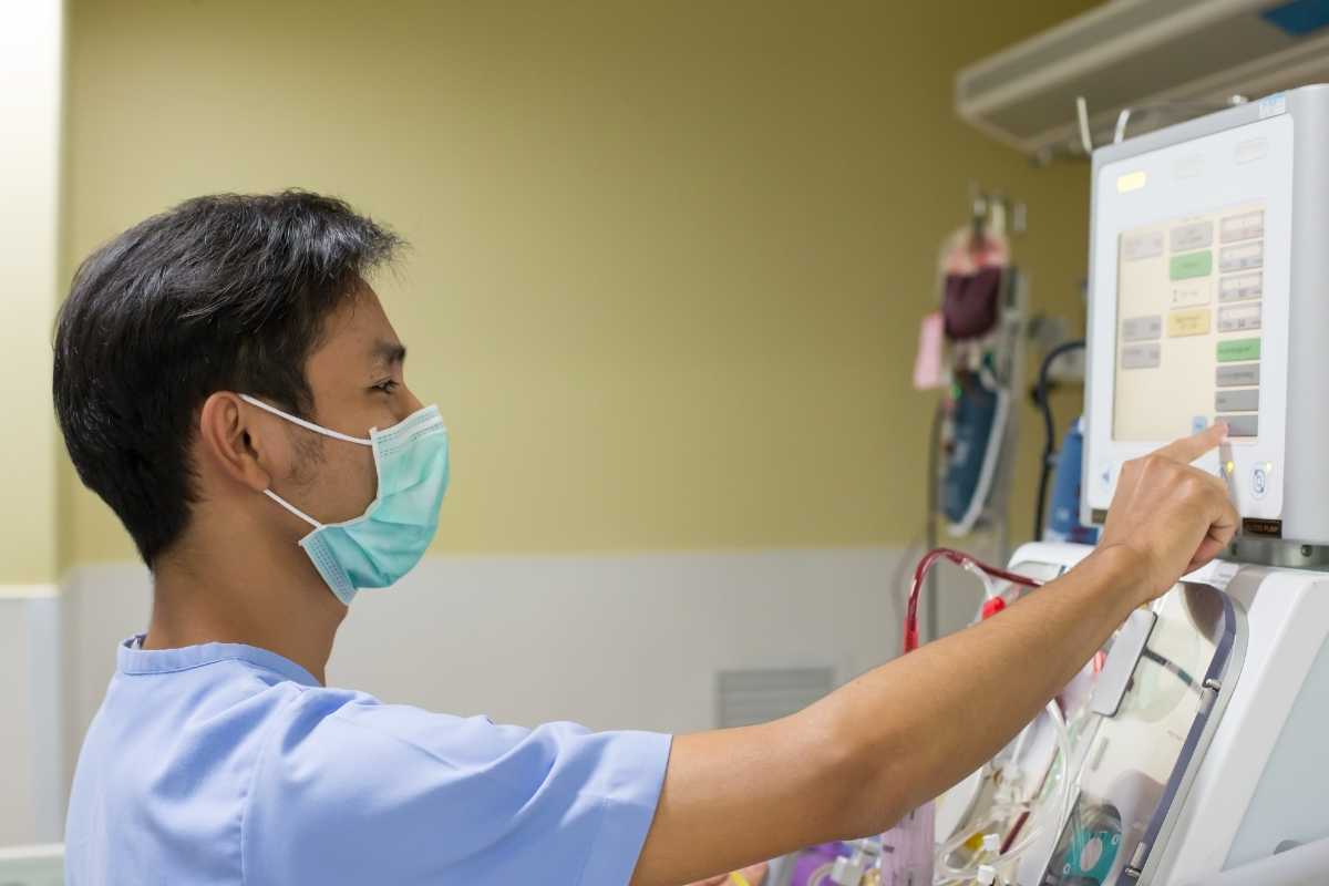 Nurse with CCRN certification checking digital screen in a hospital room