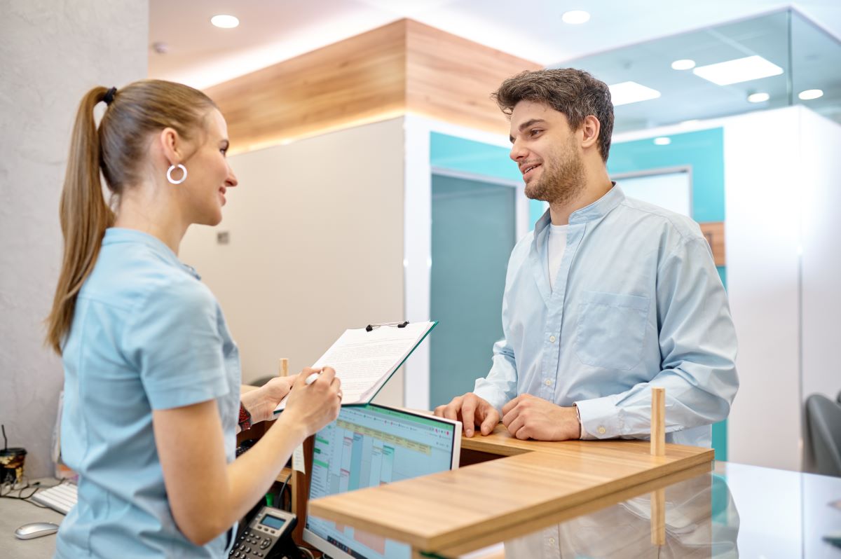 A patient checks in at the front office, one of the first parts of the patient journey.