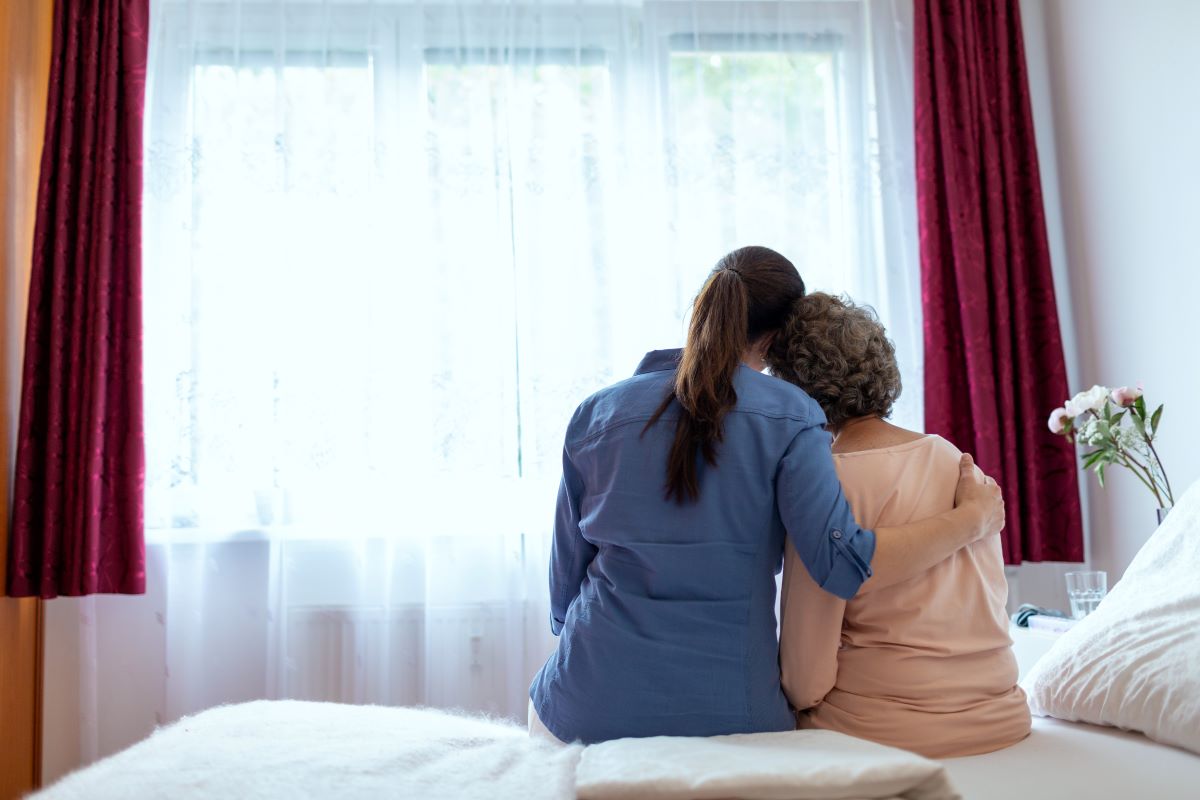 A hospice nurse embraces one of her patients.