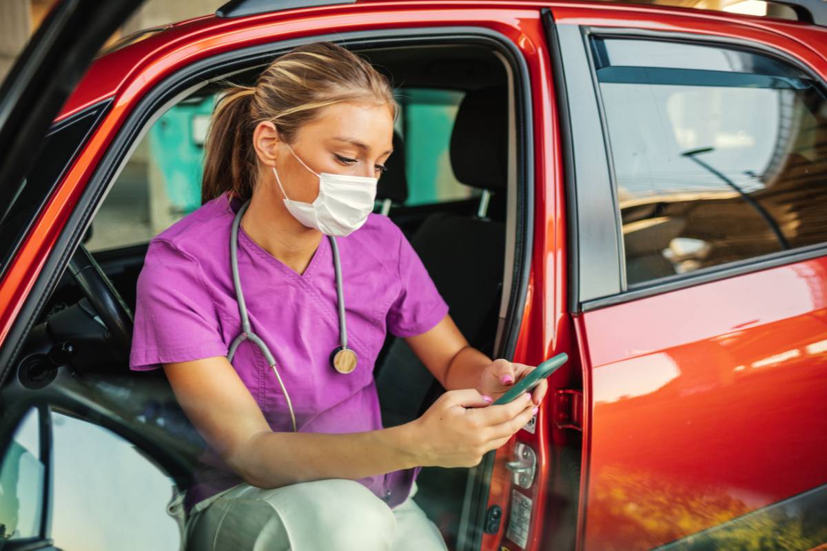 A nurse sits in her car and researches, Can you be a travel nurse in your own city?