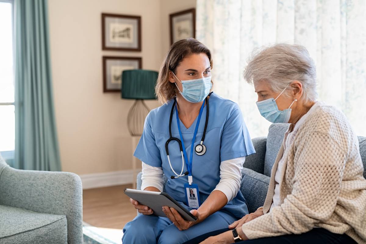 A healthcare professional uses her home health aide resume skills to assist a client.