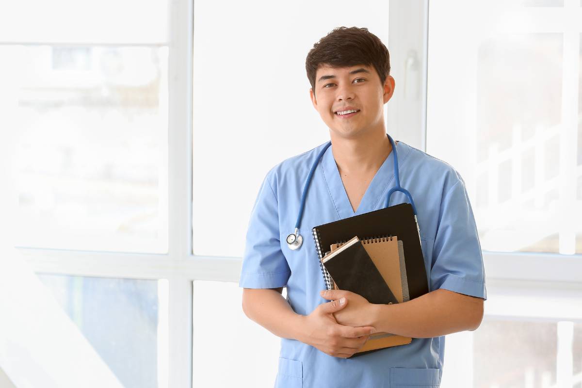 A nurse prepares for their AMT certification by gathering their study materials.