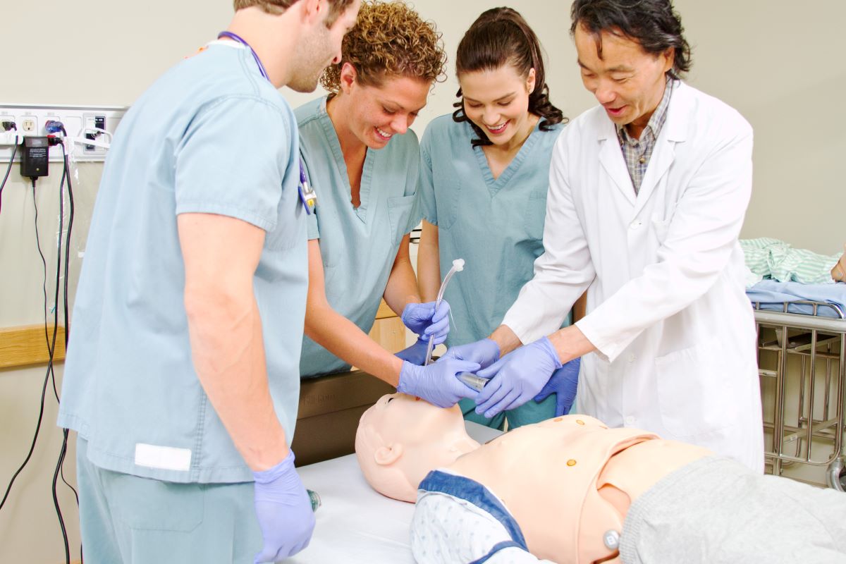 Nursing students learn how to intubate a patient using a dummy.