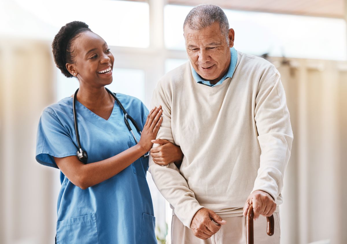 A nurse assists a nursing home resident with walking.