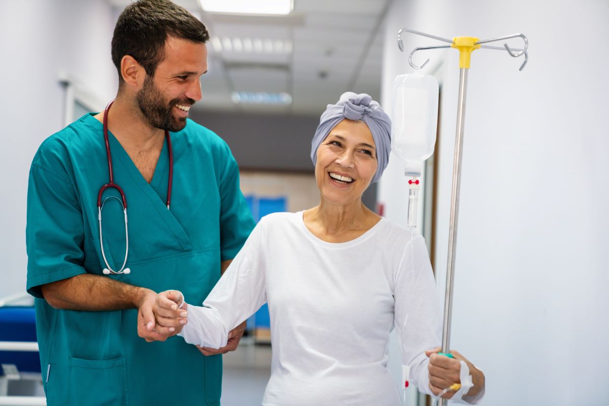 An oncology nurse assists one of his cancer patients after a medical procedure.