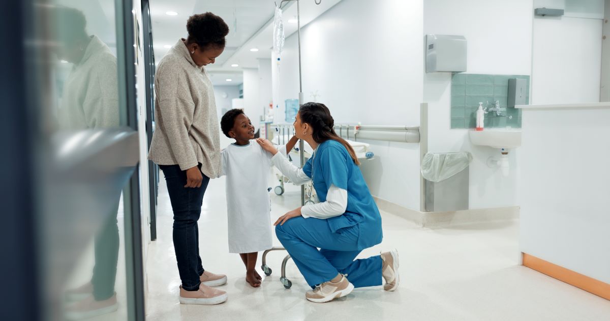 An OR nurse meets with a child patient prior to an operation.