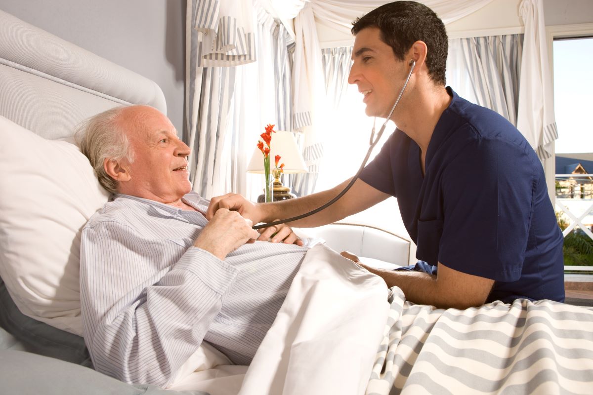A PCU nurse checks in on his patient.