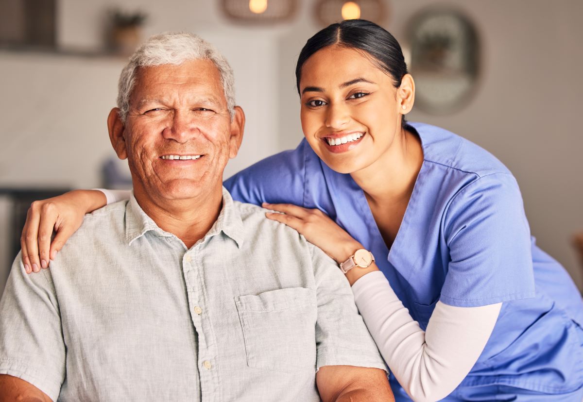 A nurse poses with one of her nursing home residents.