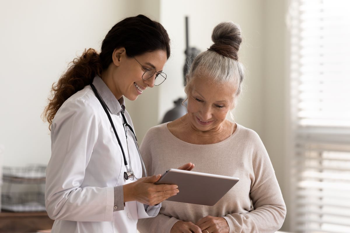 A nurse practitioner reviews written medical instructions with an older woman