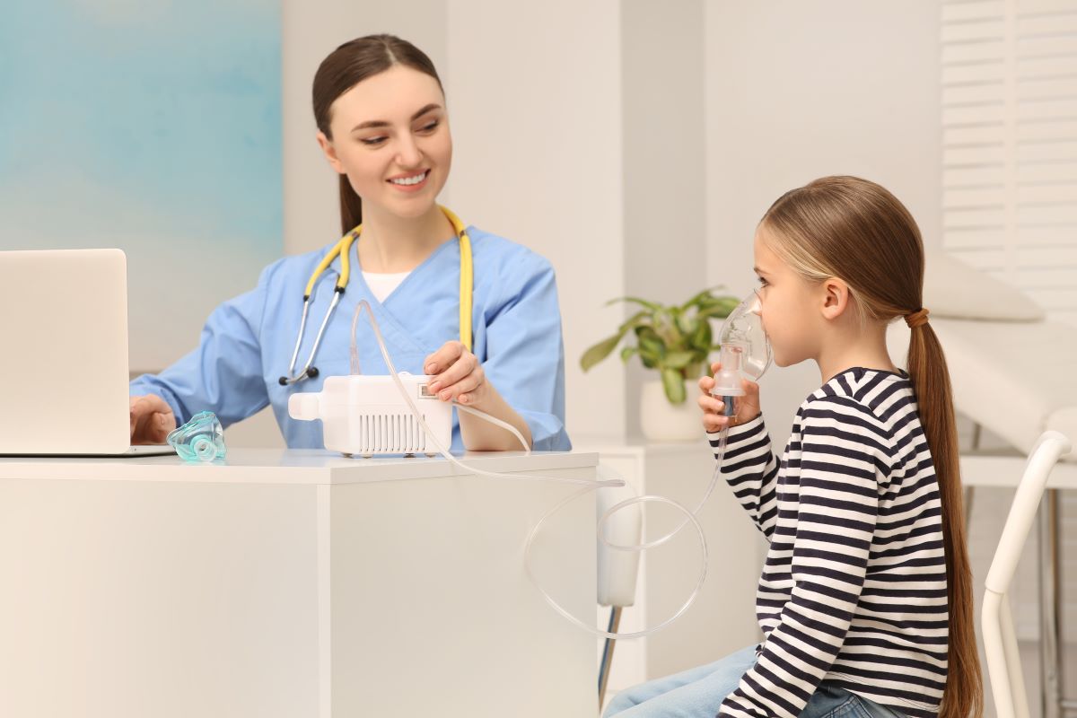 A school nurse helps a young student with a treatment.