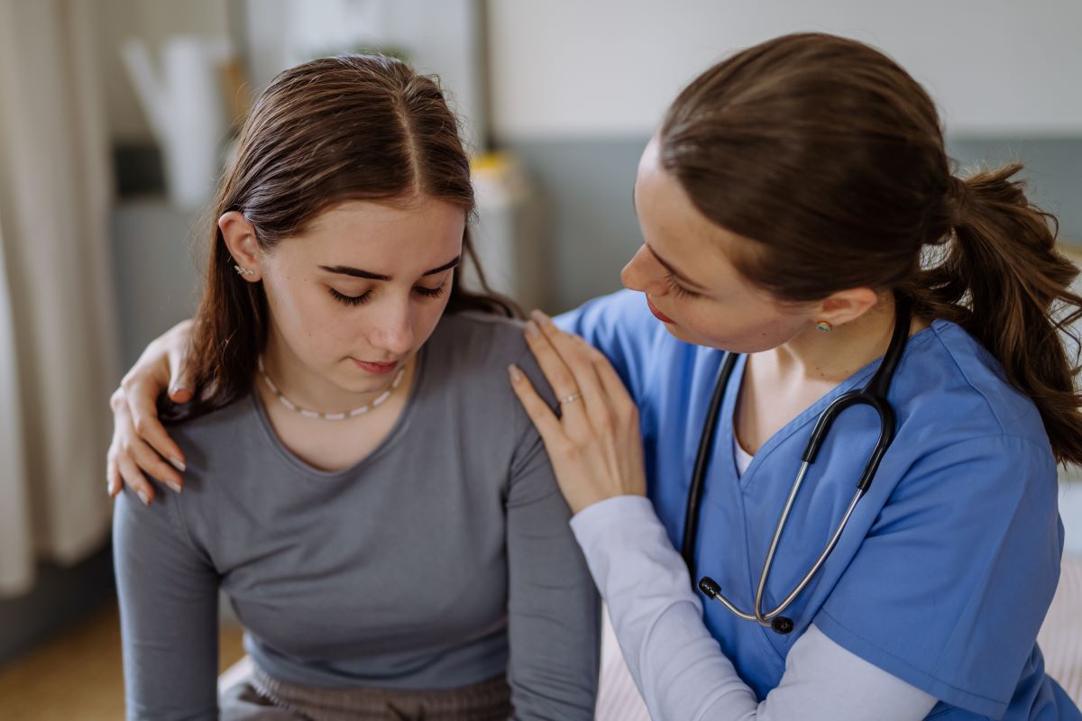 A nurse comforts a patient while applying the COWS scale to assess her opioid withdrawal symptoms.