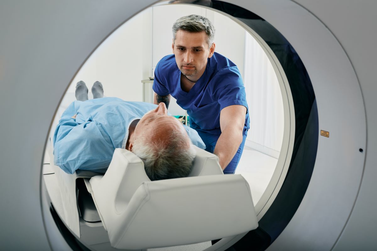 An interventional radiology nurse assists a patient with a CT scan.