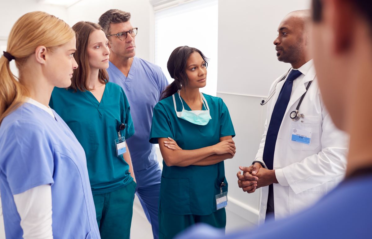 Group of six people talking during a nursing staff meeting