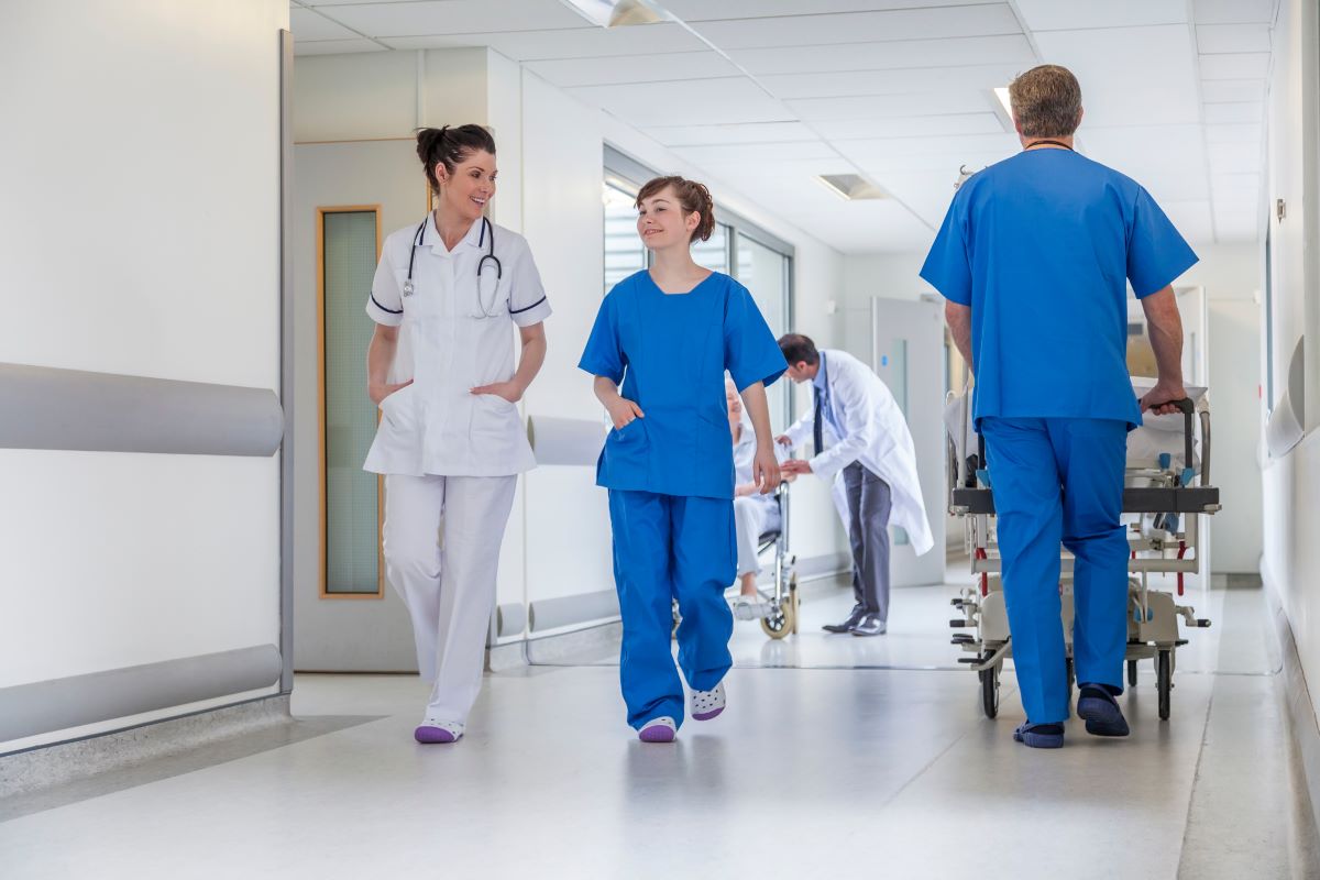 Nurses and doctors in the hallway of a hospital.