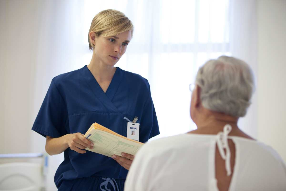 A female nurse exhibiting professional boundaries in nursing with an older male patient.