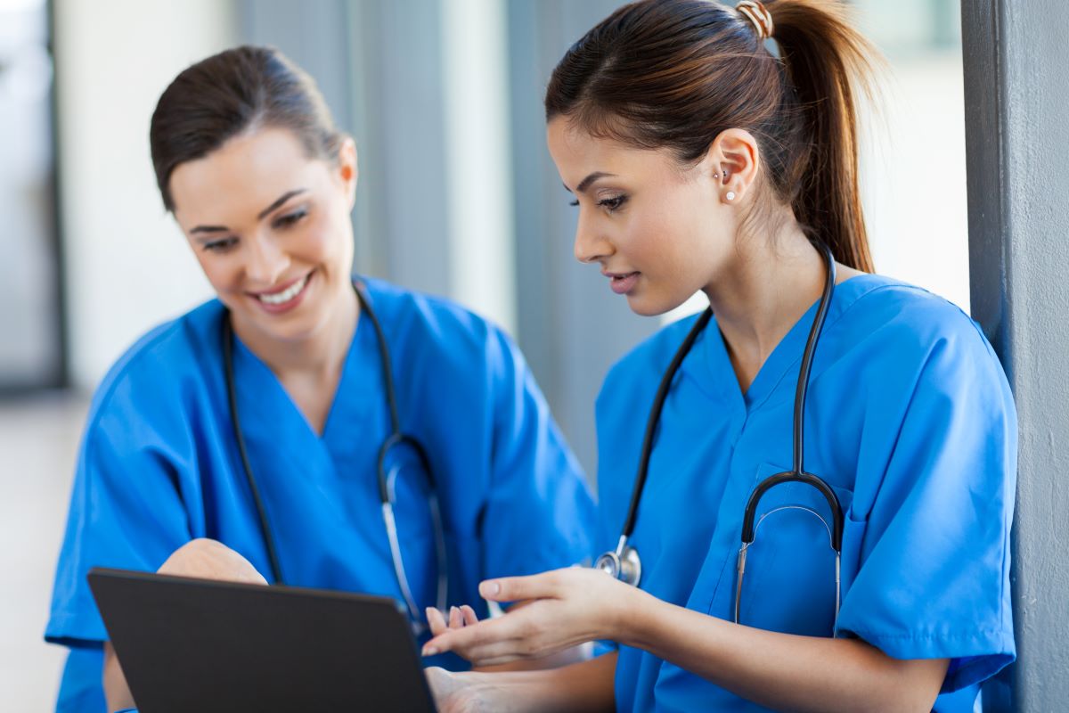 Two nurses looking at the available shifts as they engage in the practice of shift bidding.