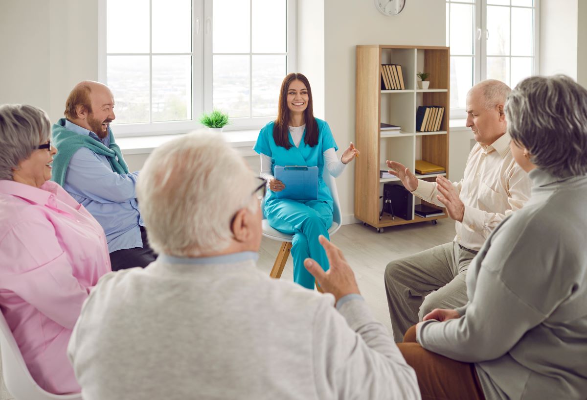 A behavioral health nurse leads a group therapy session.