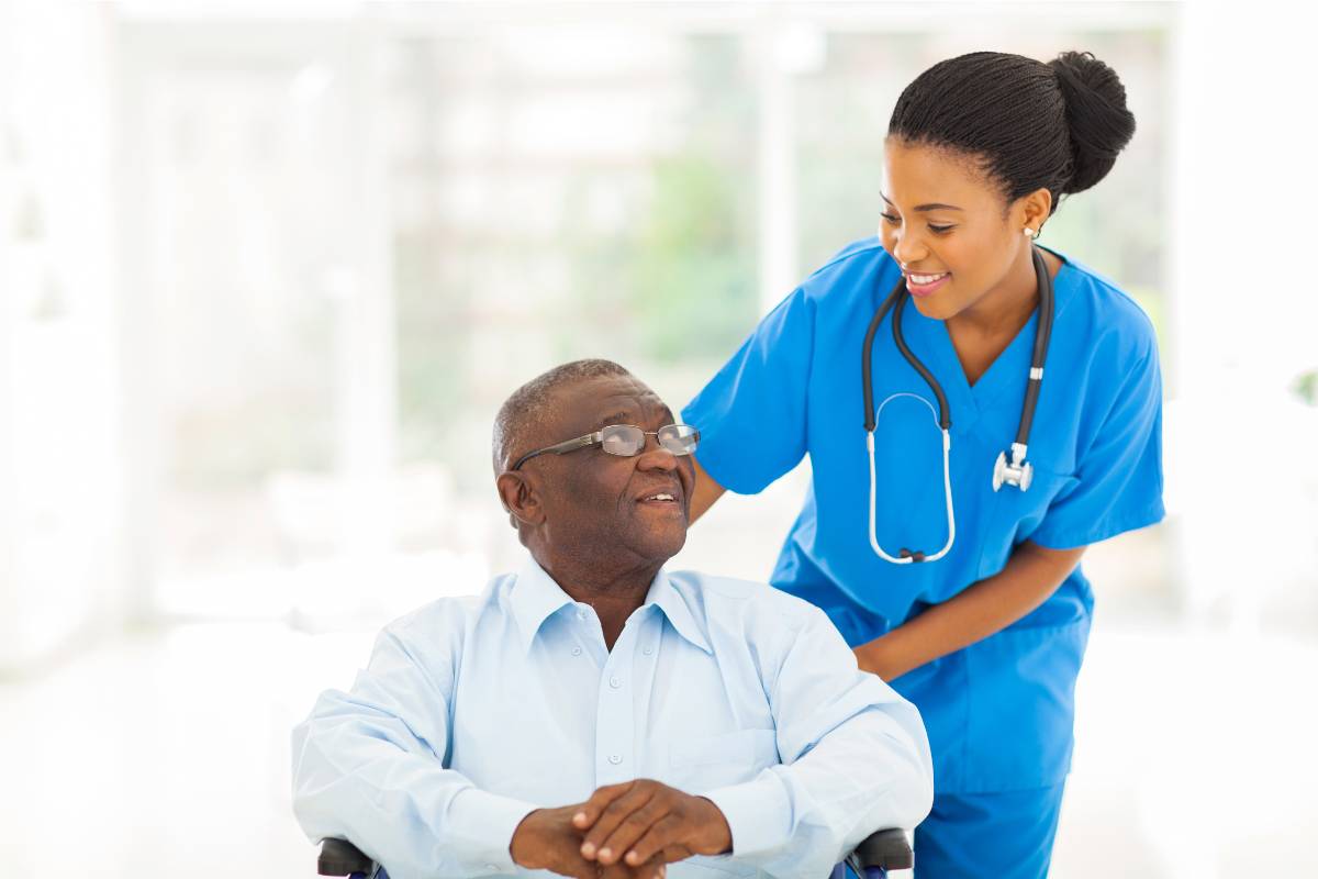 A certified dementia practitioner works with a patient in a wheelchair.