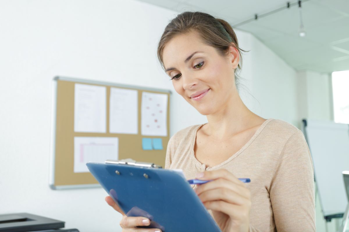 A hospital's chief nursing officer reads data from a clip board in her office.