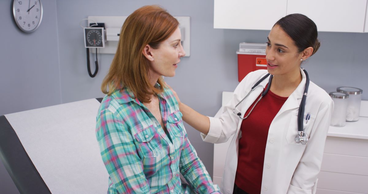 An advanced practice nurse, with a DNP degree, talks with a patient.