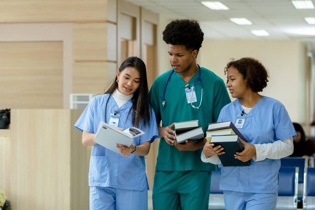 A group of students discusses grand nursing theories while walking to class.