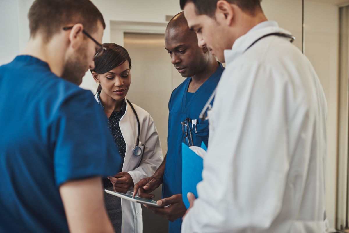 Nurses and physicians go over a patient's chart.