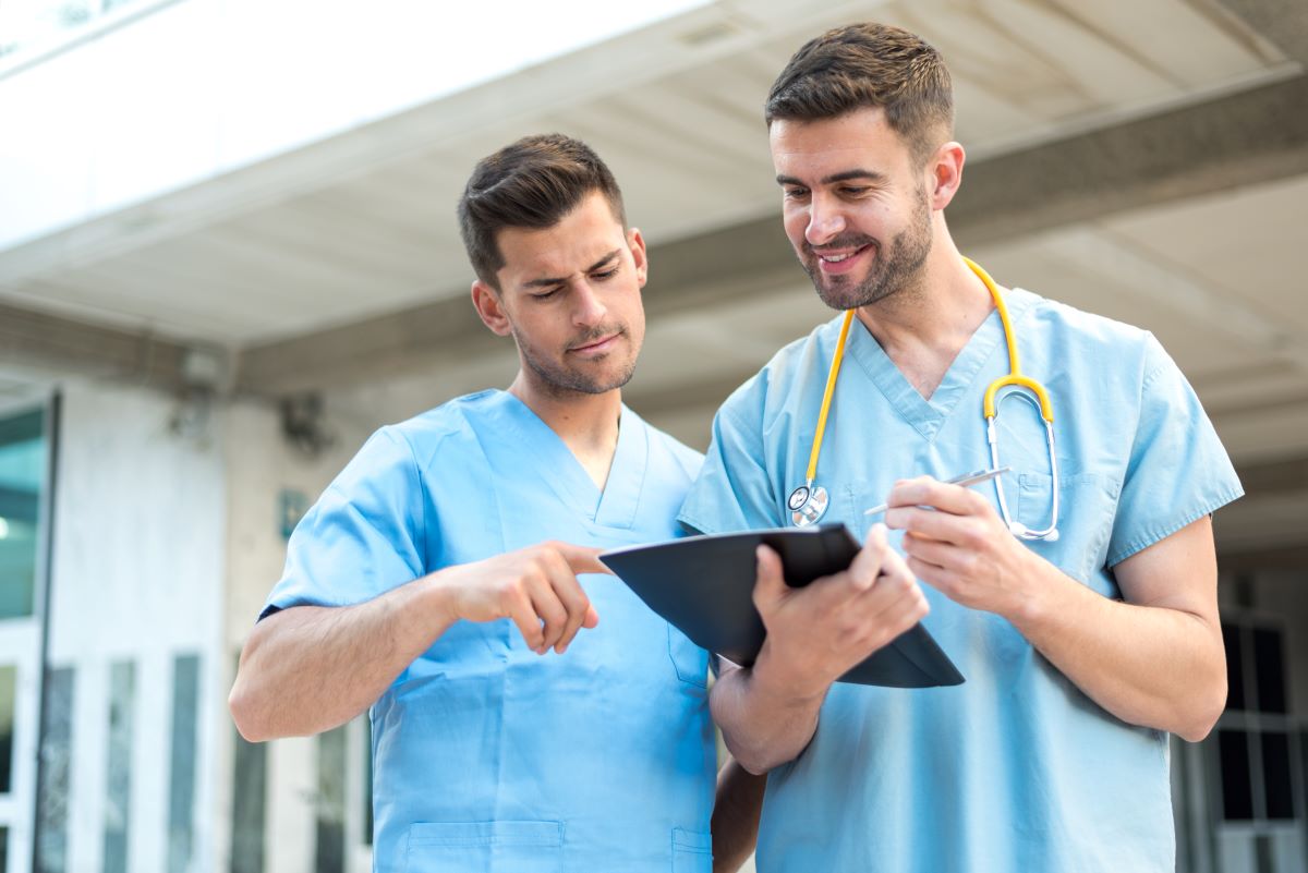 Two nurses discuss a patient's chart.