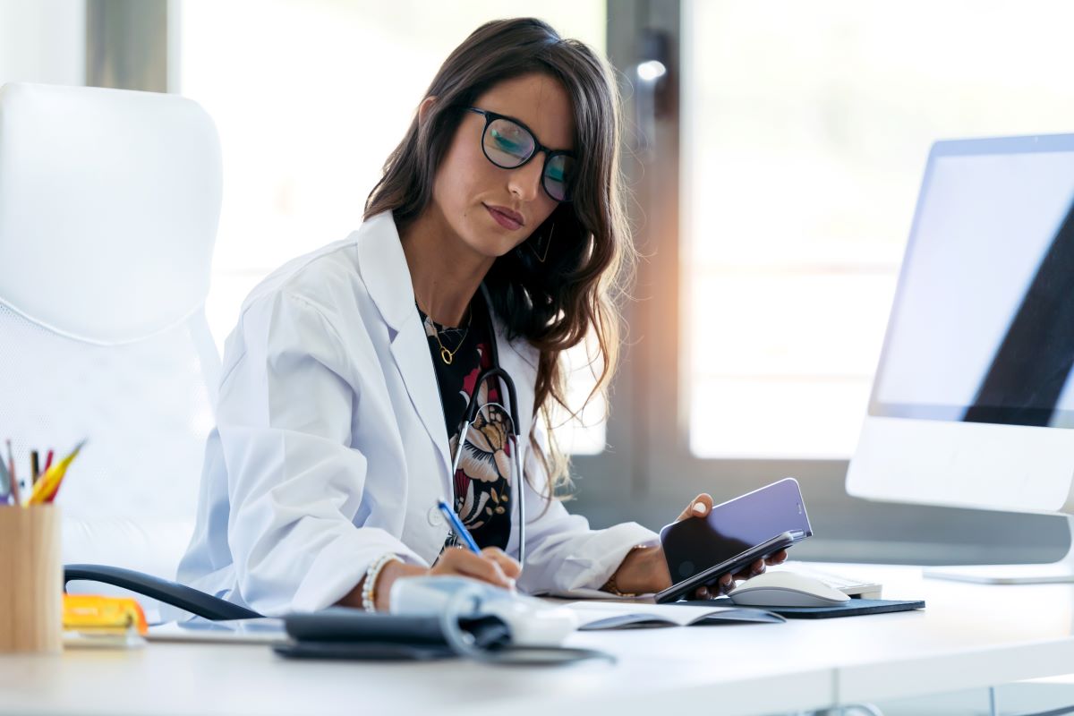 A nurse practitioner at her desk, reviewing patient data.