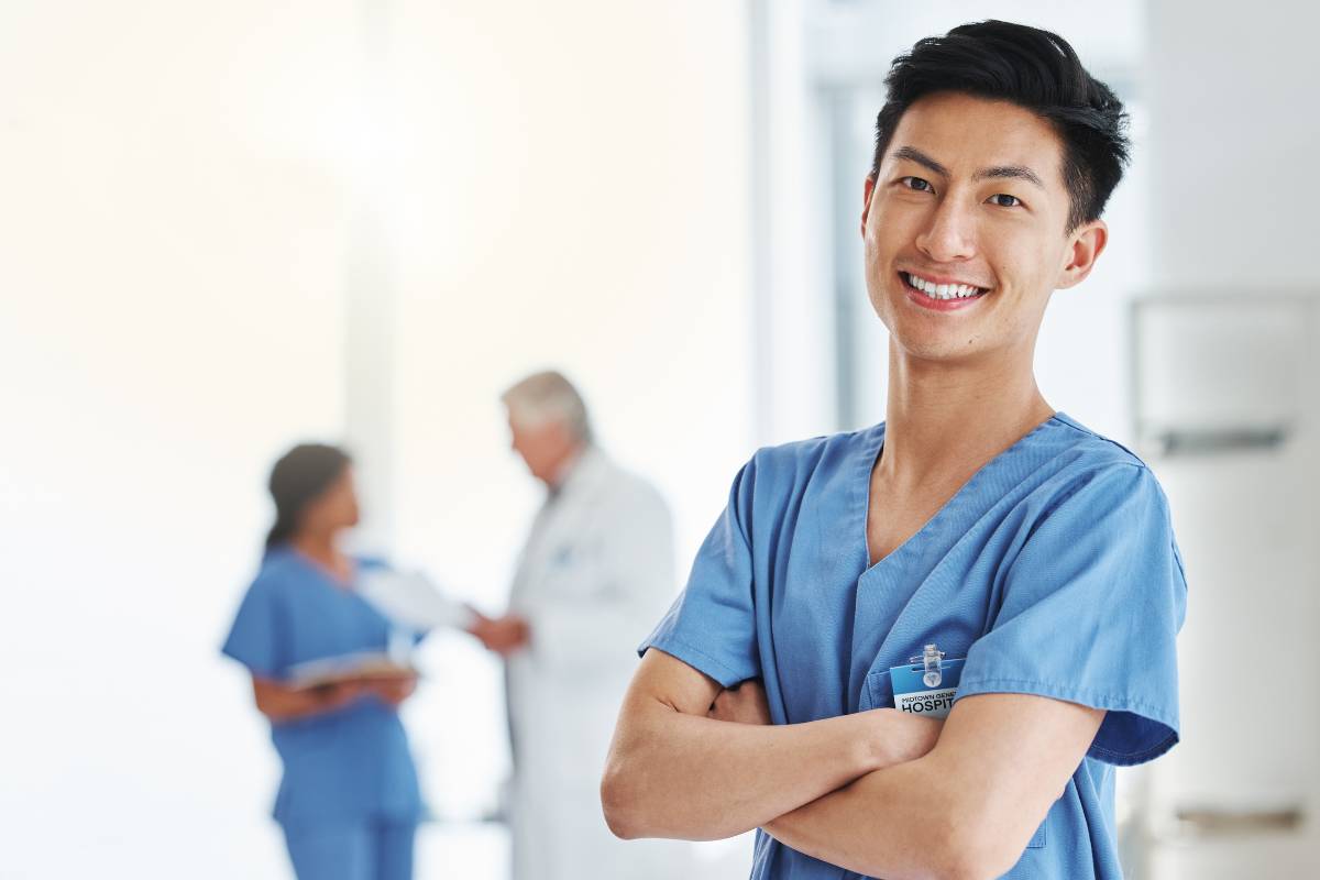 A nurse with CPHON certification stands in a hospital hallway.