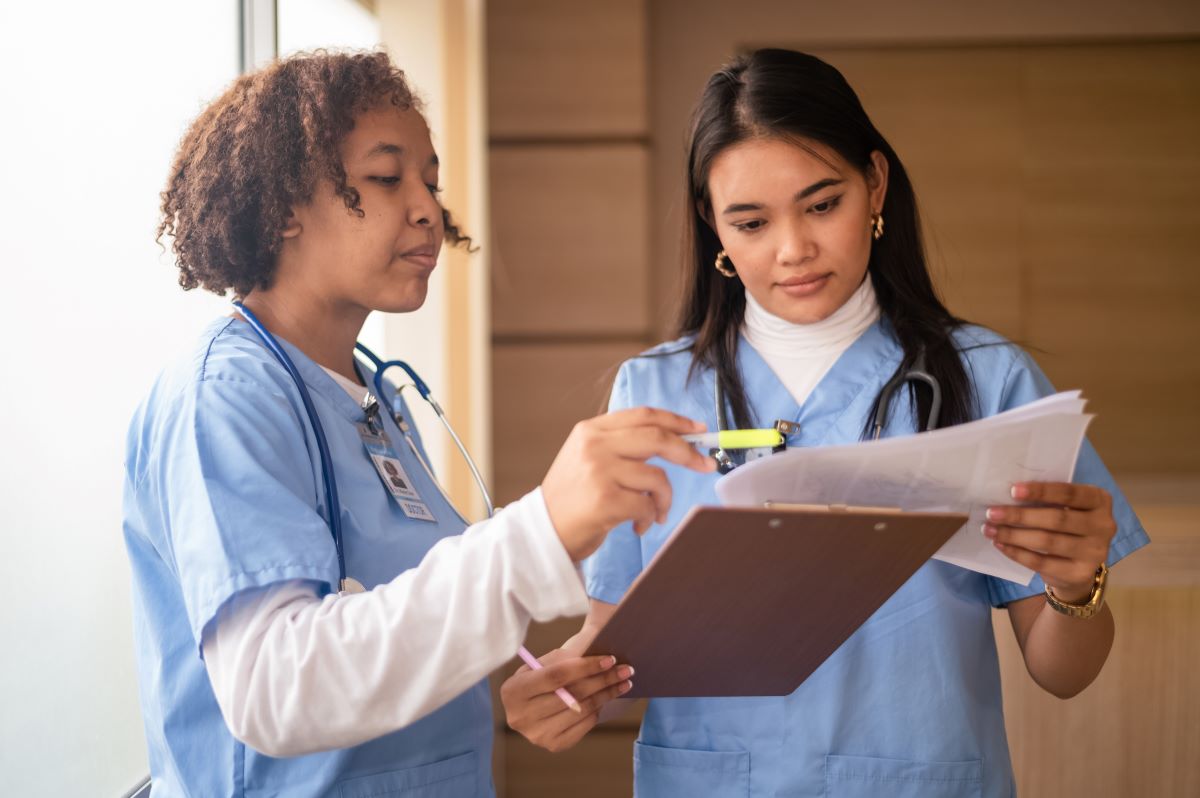 Two nurses looking at documents as they complete the credentialing process for providers.