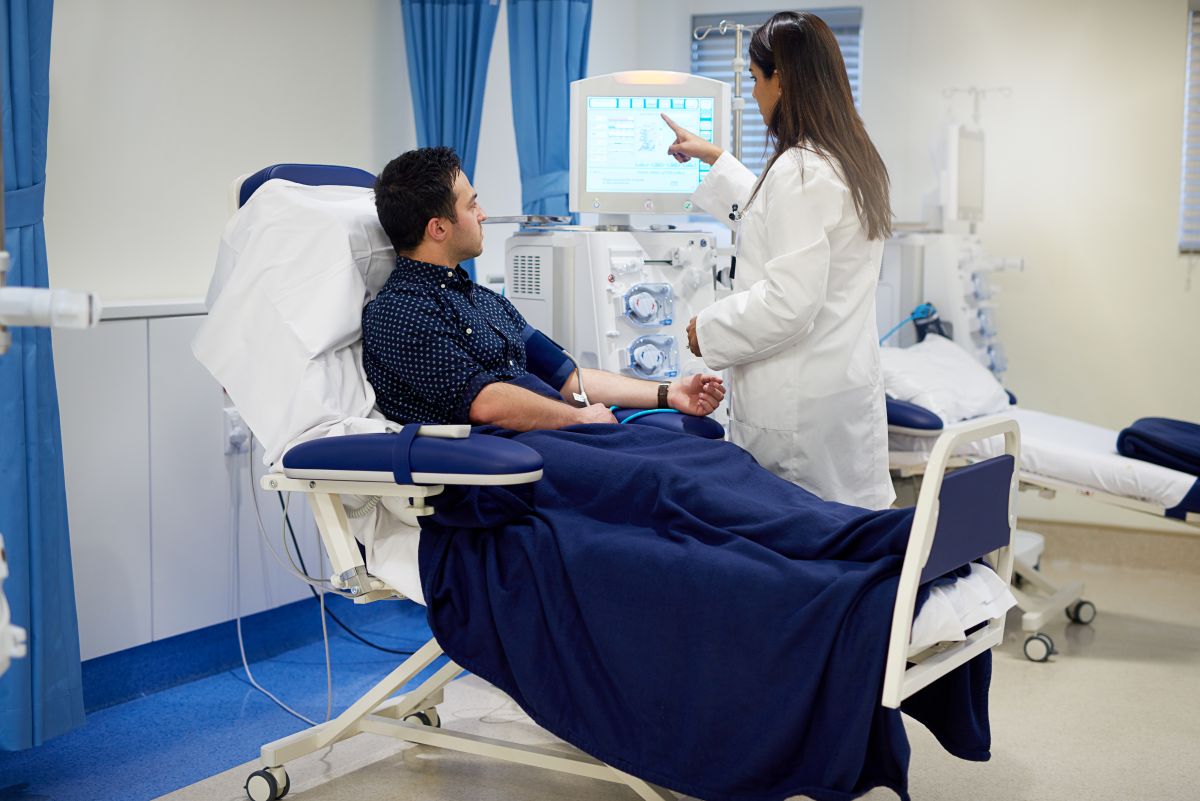 A dialysis nurse prepares a patient for their procedure.