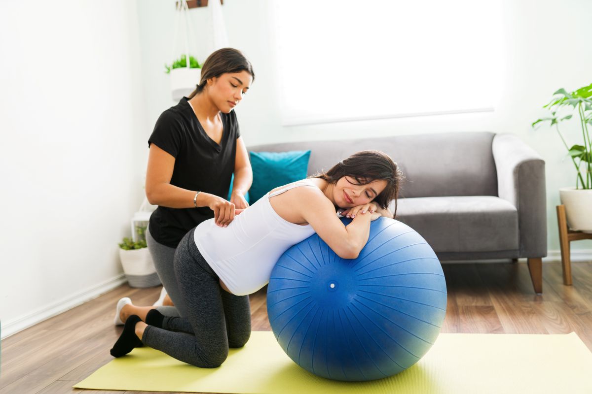 A doula assists a pregnant client with her labor.