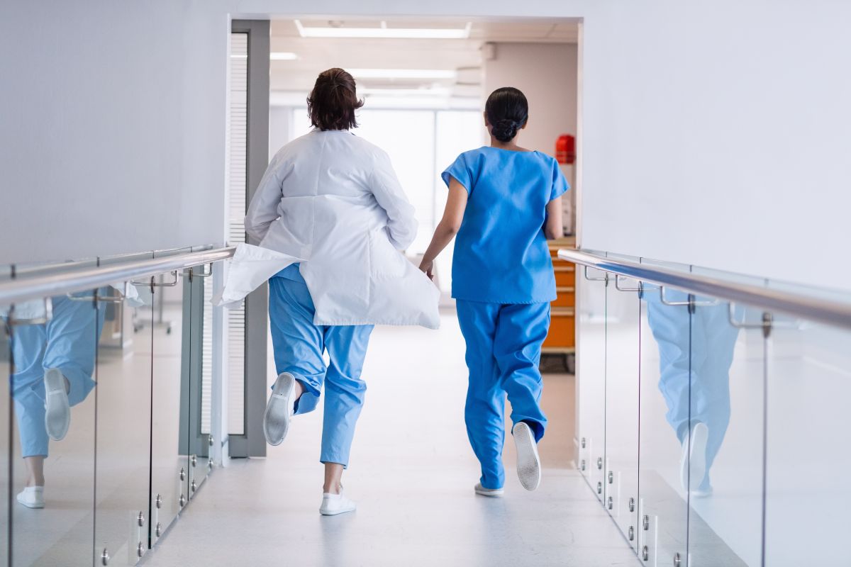 Medical personnel run down the hall as they respond to an emergency.