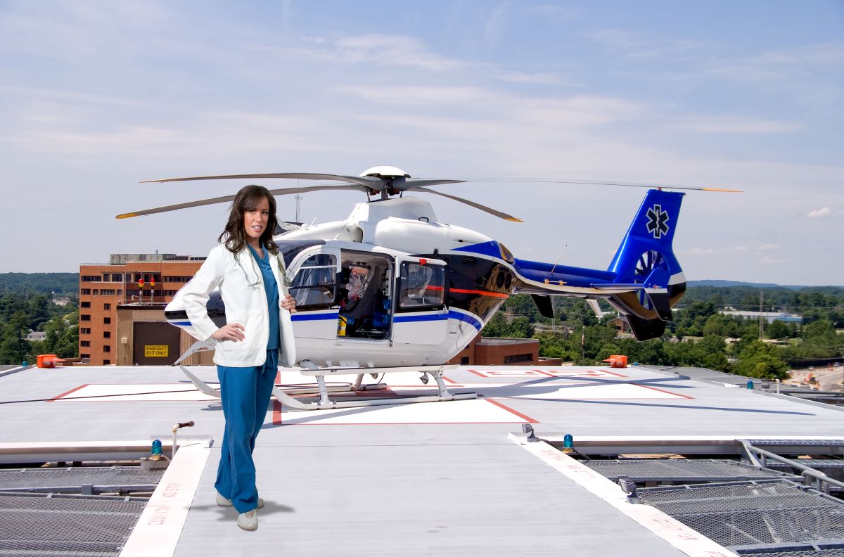 A flight nurse poses in front of her medical response helicopter.