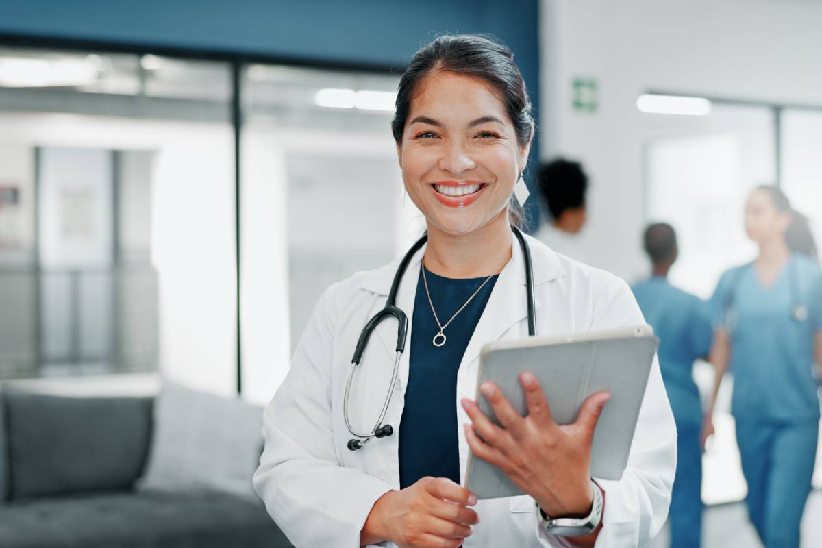 A nursing executive with NEA-BC certification holds a tablet.