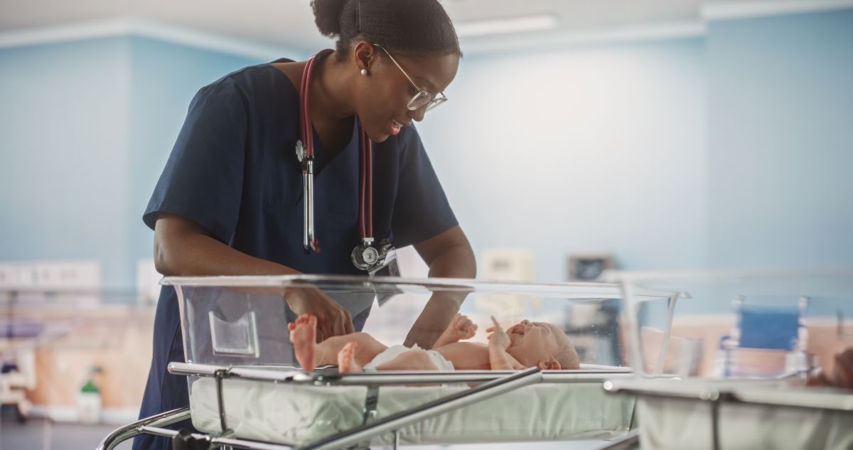 A neonatal nurse checks on a newborn baby.