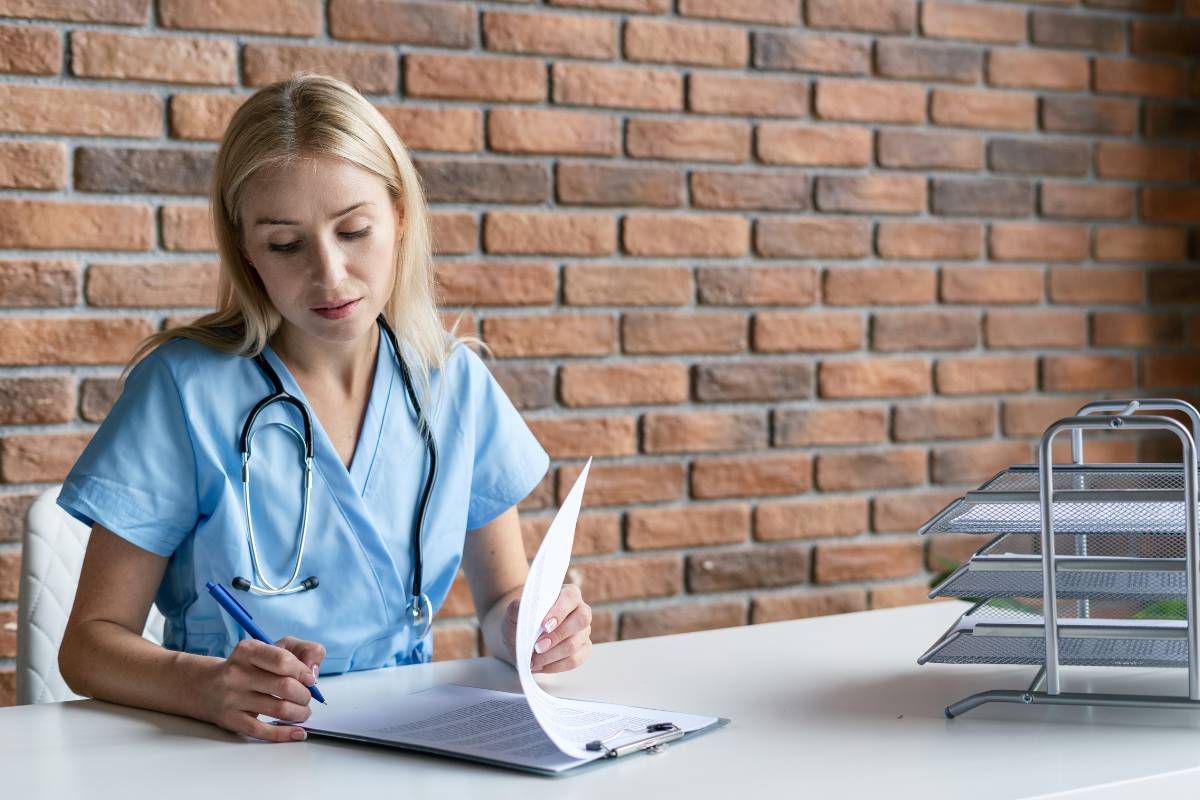 A nurse sitting at a table and signing her nursing sign-on bonus.