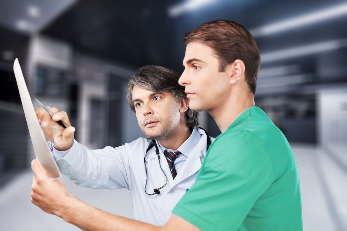 A nursing supervisor goes over a patient's chart with one of his charges.