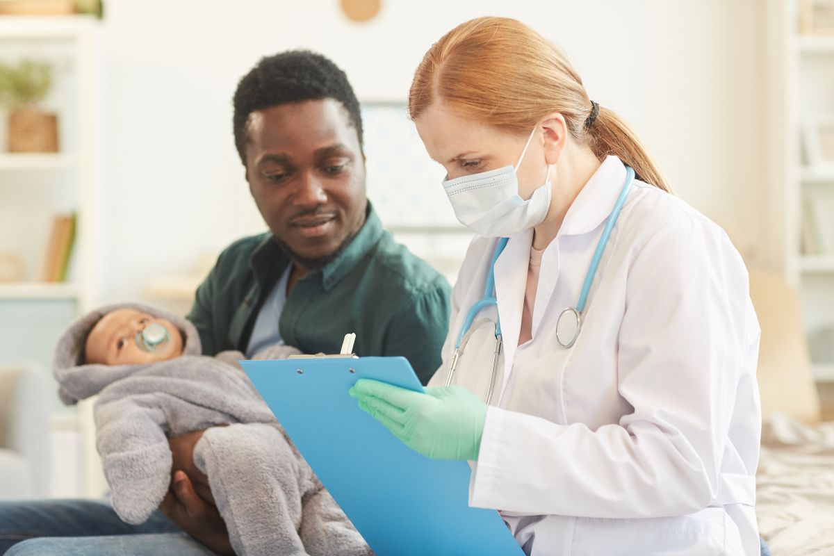 A postpartum nurse consults with a new dad and his baby.